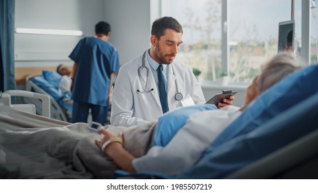 Hospital Ward: Friendly Doctor Talks to Beautiful Senior Female Patient Resting in Bed, Explains Test Results, Gives Recovery Advice. Physician Talks to Old Lady Recovering after Successful Surgery - Powered by Shutterstock