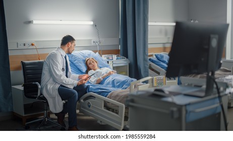 Hospital Ward: in Modern Equipment Clinic Surgeon Using Tablet Computer Consulting Patient Recovering After Successful Surgery in Bed. Modern Advanced High-Tech Medical Center - Powered by Shutterstock