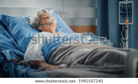 Hospital Ward: Portrait of Beautiful Elderly Woman Wearing Oxygen Mask Sleeping in Bed, Fully Recovering after Sickness. Old Lady Dreaming of Her Family, Friends, Happy Life.