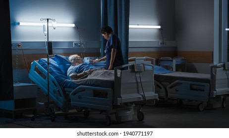 Hospital Ward: Portrait Of Elderly Man Wearing Oxygen Mask Resting In Bed, Struggling To Recover After Covid-19, Sickness, Disease, Surgery. Old Man Fighting For His Life. Dark Blue Sad Shot