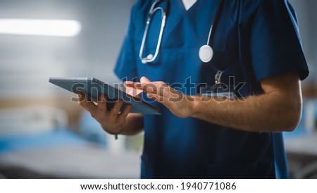 Hospital Ward: Unrecognizable Head Nurse, Doctor, Surgeon Uses Digital Tablet Computer Health Care Vitals Monitoring Computer Machine. Modern Clinic with Advanced Equipment and Professional Working