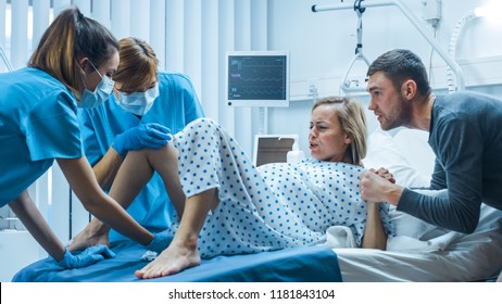 In the Hospital, Woman in Labor Gives Birth, Obstetricians and Doctors Assist, Her Husband Supports Her by Holding Hand. Modern Maternity/ Delivery Ward with Professional Midwives. - Shutterstock ID 1181843104