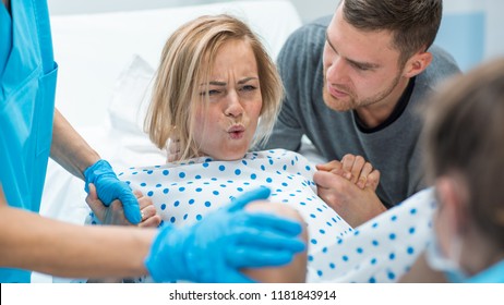 In the Hospital Woman in Labor Pushes to Give Birth, Obstetricians Assisting, Husband Holds Her Hand for Support. Modern Delivery Ward with Professional Midwives. - Shutterstock ID 1181843914