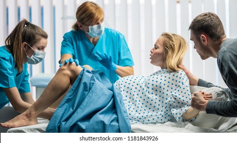 In the Hospital Woman in Labor Pushes to Give Birth, Obstetricians Assisting, Spouse Holds Her Hand. Modern Maternity Hospital/ Delivery Ward with Professional Midwives. - Shutterstock ID 1181843926