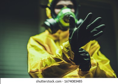 Hospital Worker Wearing Hazmat Suit and Hand Protection Gloves Preparing For Work During Global Pandemic.