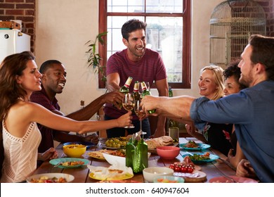 Host And Friends Making A Toast At A Dinner Party