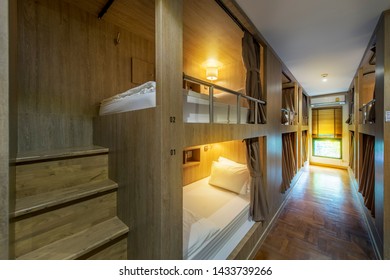 Hostel Dormitory Beds Arranged In Dorm Room With White Plain Bunk Bed In Dormitory.Hotel Dormitory Have Many Beds Arranged In One Room. Clean Hostel Small Room With Wooden Bunk Beds. 