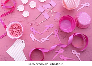 Hosting An Event For Pink Ribbon Day, Breast Cancer Awareness Fundraising, With Cupcake Decorations On A Vintage Pink Wood Table. 