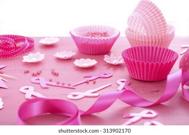 Hosting An Event For Pink Ribbon Day, Breast Cancer Awareness Fundraising, With Cupcake Decorations On A Vintage Pink Wood Table. 