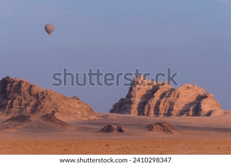Hot air balloon above the mountains at sunrise in the famous Wadi Rum desert in Jordan