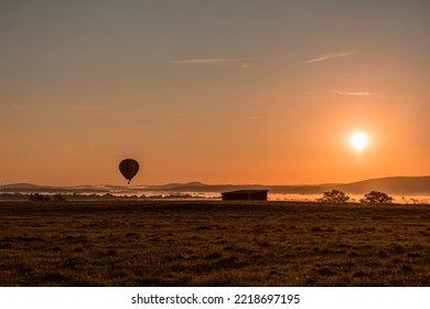 Hot Air Balloon Is Basked In A Golden Glow As It Slowly Ascends Over A Fog-filled Valley In Orange County, NY, On An Early Fall Morning