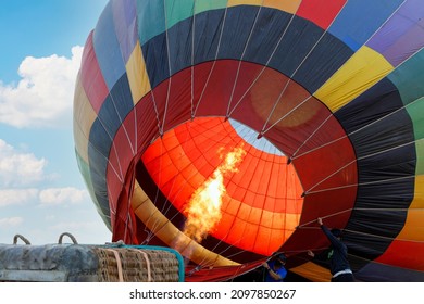 hot air balloon flying into the sky. A hot air balloon is raised with flames burning from a gas stove or propane stove equipment.