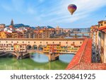 Hot air balloon flying over Ponte Vecchio over Arno river in Florence, Italy