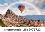 Hot air balloon flying over fairy chimneys and rock landscape at Cappadocia, Turkey