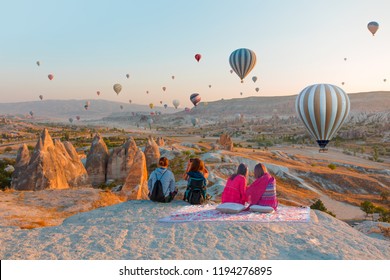 Hot air balloon flying over spectacular Cappadocia - Girls watching Hot air balloon at the hill of Cappadocia