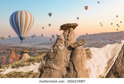 Hot air balloon flying over fairy chimneys and rock landscape at Cappadocia Turkey