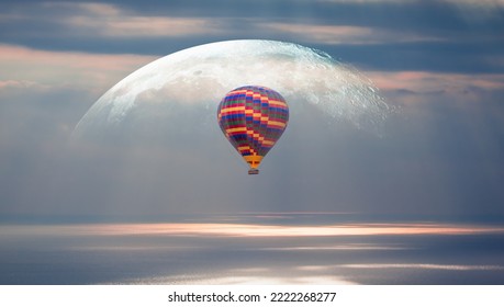 A hot air balloon flying over the sea full moon in the background at sunset 