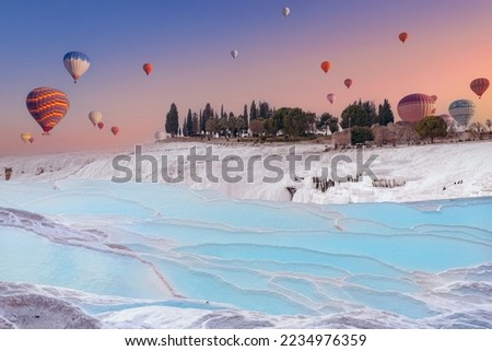 Hot air balloon flying Pamukkale Travertine pool and terraces sunset, travel Turkey.