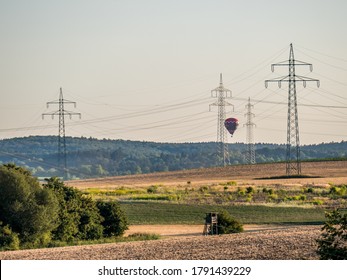 Hot Air Balloon Hovering Behind Power Poles