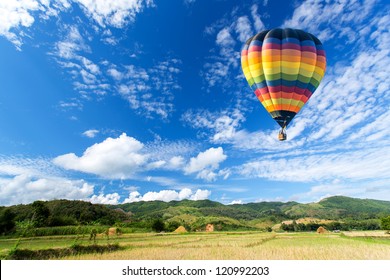 Hot air balloon over the field with blue sky