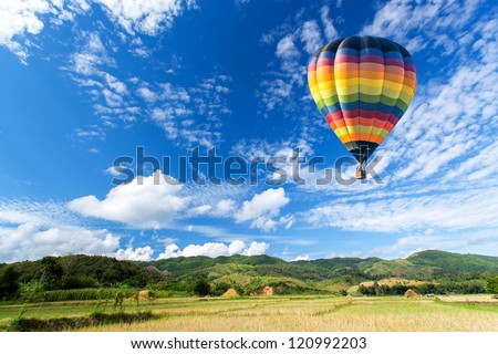 Hot air balloon over the field with blue sky