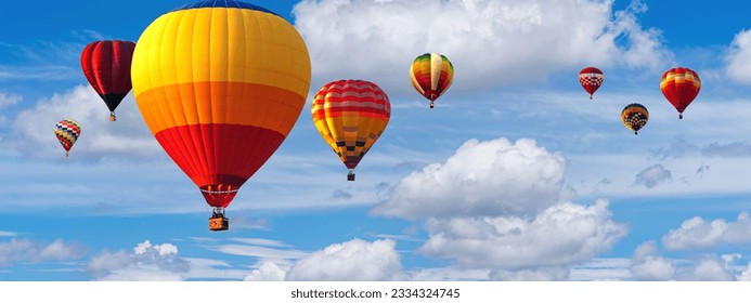 Hot Air Balloon Ride in blue sky white clouds background for wide banner of travel agency or adventure tour. Romance of ballooning in a good weather. Hot air balloons flies in blue sky. Copy space