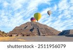 Hot air balloons flying over ancient pyramid of Teotihuacan at amazing sunset, Mexico