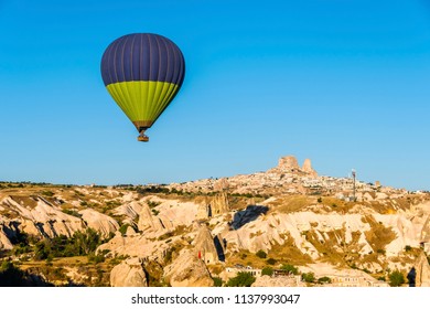 Hot Air Balloons are flying over Uchisar Castle in Cappadocia Region of Turkey.