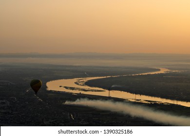 Hot Air Balloons Flying Over The Nile River In Luxor, Egypt At Sunrise.