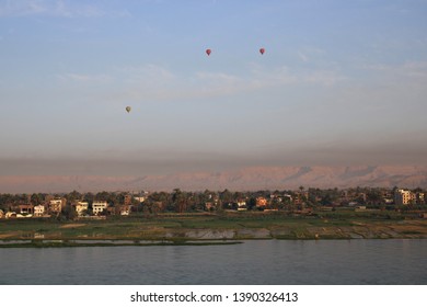 Hot Air Balloons Flying Over The Nile River In Luxor, Egypt At Sunrise.