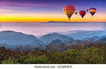Hot air balloons flying over sea of mist awakening in a beautiful hills at sunrise in Chiang Mai, Thailand. - Shutterstock ID 1513092875