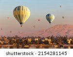 Hot air balloons over Nile river and Valley of Kings in Luxor at sunrise in Egypt