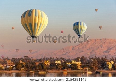 Hot air balloons over Nile river and Valley of Kings in Luxor at sunrise in Egypt
