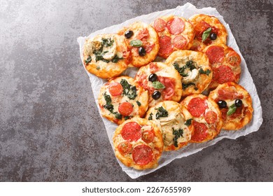 Hot assorted mini pizza or Pizzette with various toppings close-up on parchment on the table. horizontal top view from above
 - Powered by Shutterstock