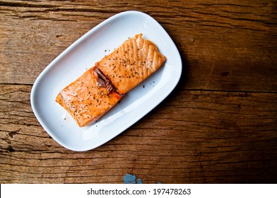 Hot Baked Salmon Fillet Piece Served Over White Plate On Wood Table Background, Delicious Healthy Food, Country Rustic Style.