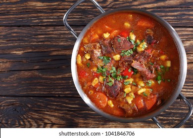 Hot Beef Hungarian Goulash Or Bograch Soup With Paprika, Small Egg Pasta, Vegetables And Spices In A Pot On Wooden Table, Classic Recipe, View From Above, Close-up