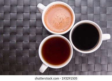 Hot Beverages Of Tea, Chocolate And Black Coffee On A Woven Place Mat