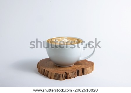 Hot cafe Latte espresso coffee in white ceramic cup on wood saucer with rosetta latte art isolated in white background.