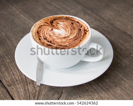 Hot cappuccino on a wooden table.
