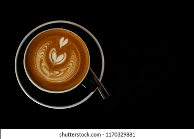 Hot cappuccino top view, black as background with copy space