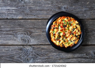 Hot Chicken Tamale Pie Of Cornmeal Crust With Pulled Chicken, Cheddar Cheese, Black Bean Filling Baked On A Black Baking Dish Sprinkled With Parsley On Top, Top View, Copy Space