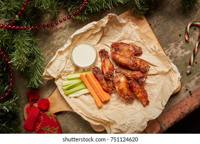 Hot Chicken Wings On The Paper And Christmas Background Around It. 