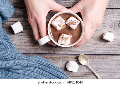 Hot chocolate with marshmallow in woman hand and sweater - Powered by Shutterstock