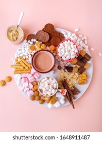 Hot Chocolate, Marshmallows, Chocolates And Cookies Charcuterie Board On Pink Background. Top View, Portrait Orientation