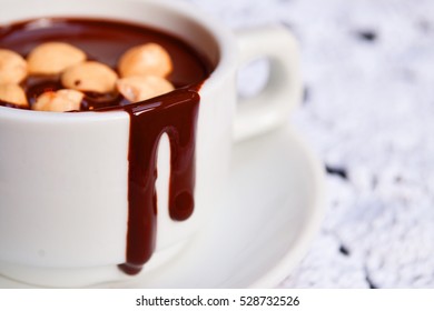 Hot Chocolate With Nuts In A White Cup On A Vintage Tablecloth.