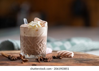 Hot Chocolate With Whipped Cream On A Wooden Cutting Board. Marshmallows And Herbes. Moody Kitchen.