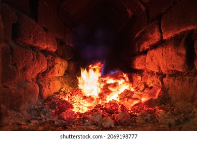 Hot Coals Inside An Old Rustic Brick Oven. There Are Yellow And Blue Flames. Background. Texture. 