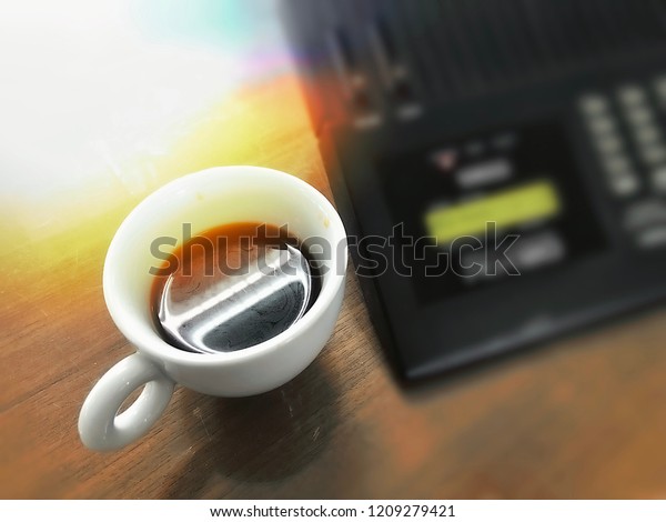 Hot\
coffee cup with blurred electronic gear\
background