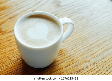Hot coffee cup of latte art,coffee on wooden table in the morning.