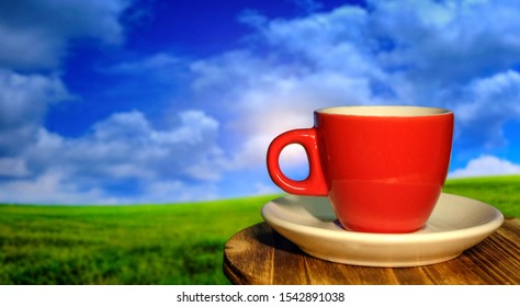 Hot coffee cup with organic coffee beans on the wooden table and the plantations background with copy space. Natural background blurred blue sky and meadow - Shutterstock ID 1542891038